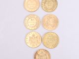 six different types of gold coins on a white surface