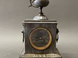 a silver clock with a bird on top of it