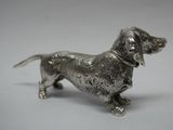 une figurine antique en argent représentant un chien, sur fond blanc