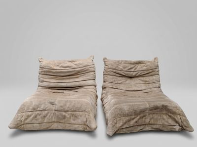 une paire de fauteuils de salon en velours beige, ornés de coussins