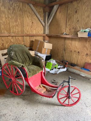 une calèche dans un garage, avec des cartons par terre