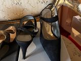 a pair of black high heeled shoes sitting on top of a box