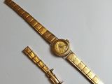 an image of a gold watch and a gold bracelet on a white surface