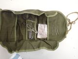 a green bag with tools in it on a table
