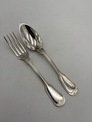 two silver spoons and a fork sitting on a table