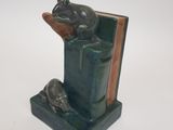 statue of a frog sitting on a book with a bookend