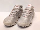 Les baskets Nike Air Max 95 blanches et rouges sont posées sur une surface blanche