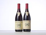 two bottles of red wine sitting on top of a table