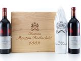 three bottles of red wine in a wooden box with a napkin