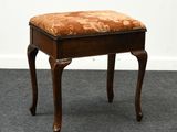un petit banc en bois avec une assise rembourrée à motifs floraux