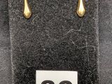 deux paires de boucles d'oreilles en or exposées dans une vitrine