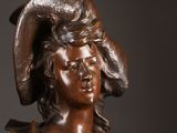 bronze statue of a woman with a hat on her head