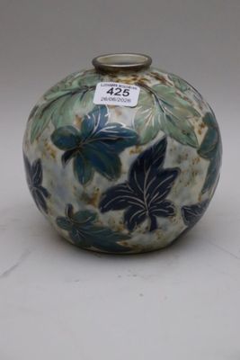 a blue and white vase with green leaves on it