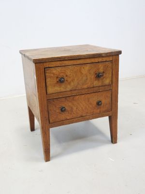 a small wooden table with two drawers on it