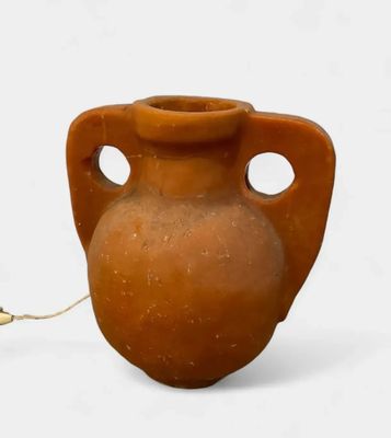 a brown vase with holes in it on a white surface