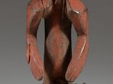 statue of a man sitting on a stool with his hands on his hips