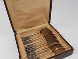 six cuillères dans un coffret en bois contenant de l'argenterie