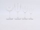 several empty wine glasses lined up in a row on a white surface