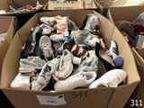 many pairs of shoes in a cardboard box on the floor
