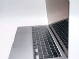 a silver laptop with a black keyboard on a white surface