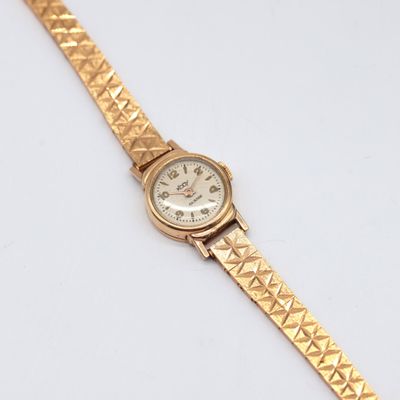 an image of a gold wrist watch on a white surface