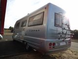 a silver camper that is parked on the side of the road