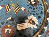 a blue and red vase with a tag on it