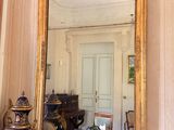 a mirror on the wall above a table with a vase