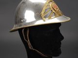 an old silver helmet with a gold emblem on the side of it