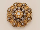 a close up of a gold and diamond broochle