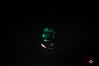 une image représentant une bouteille contenant un liquide vert dans l'obscurité