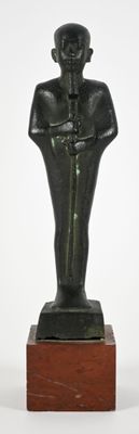 statue of a man with a hat on his head on a wooden base