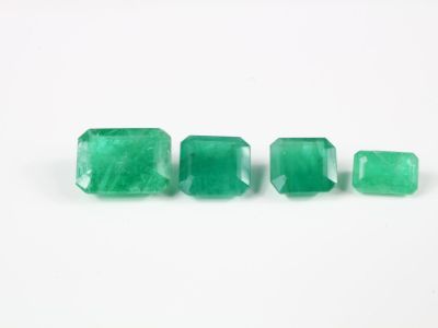 un groupe de trois pierres précieuses couleur émeraude sur un fond blanc