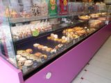 une vitrine rose remplie de différentes sortes de pâtisseries