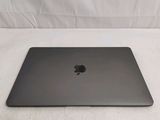 a black apple laptop sitting on top of a white sheet