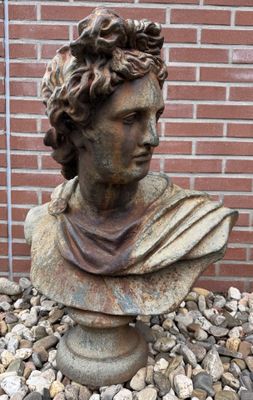 une statue représentant une femme assise sur un tas de pierres