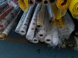 many rolls of fabric and rolls of fabric on a shelf