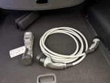 a white cable connected to a car charger in the trunk of a car