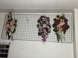 three flower arrangements hanging on a wall in a room