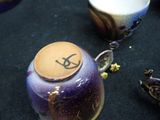 a purple vase sitting on a table next to other vases