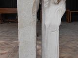 une statue représentant un homme barbu à côté d'un pilier