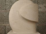 a white sculpture on a table with a brick wall in the background