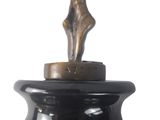 a black vase with a bronze statue on top of it
