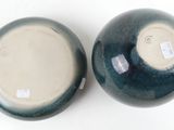 two blue and white vases sitting on a white surface