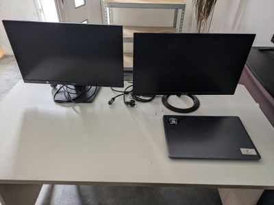 two monitors and a laptop sitting on a desk