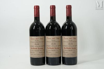 three bottles of red wine sitting on top of a white table