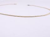 un collier ras-du-cou à chaîne en or sur fond blanc