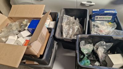 trois bacs remplis d'objets posés sur une table