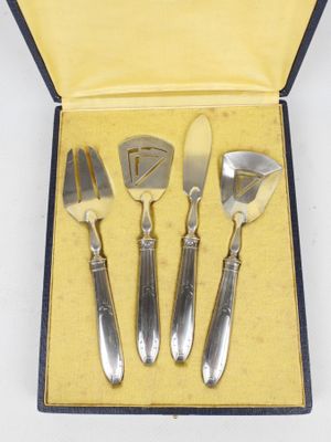 quatre couverts dans une boîte, comprenant un couteau, une fourchette et une cuillère