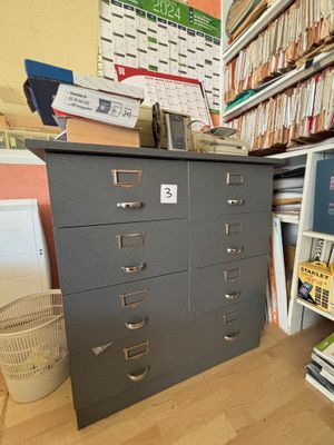 un classeur dans un coin d'une pièce où se trouvent de nombreux livres